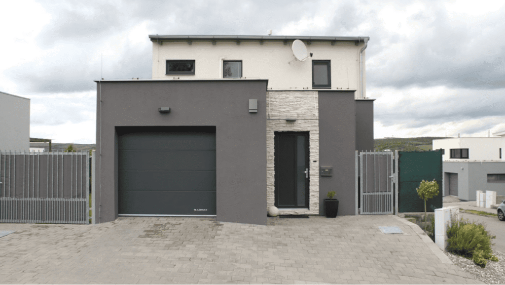 Garagentor mit Antrieb und Haustür in anthrazit