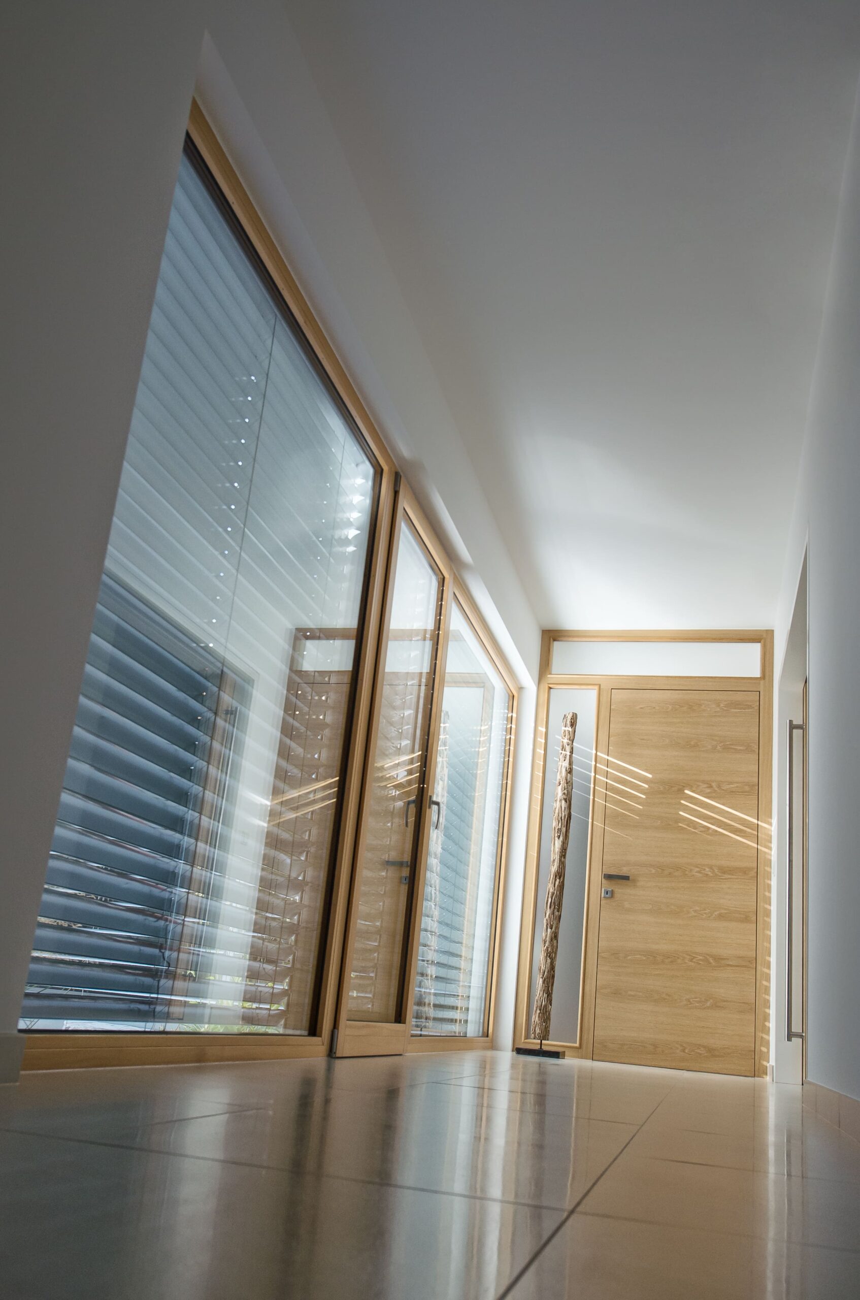 verglaster Vorraum mit Terrassentür und Eingangstür aus Holz