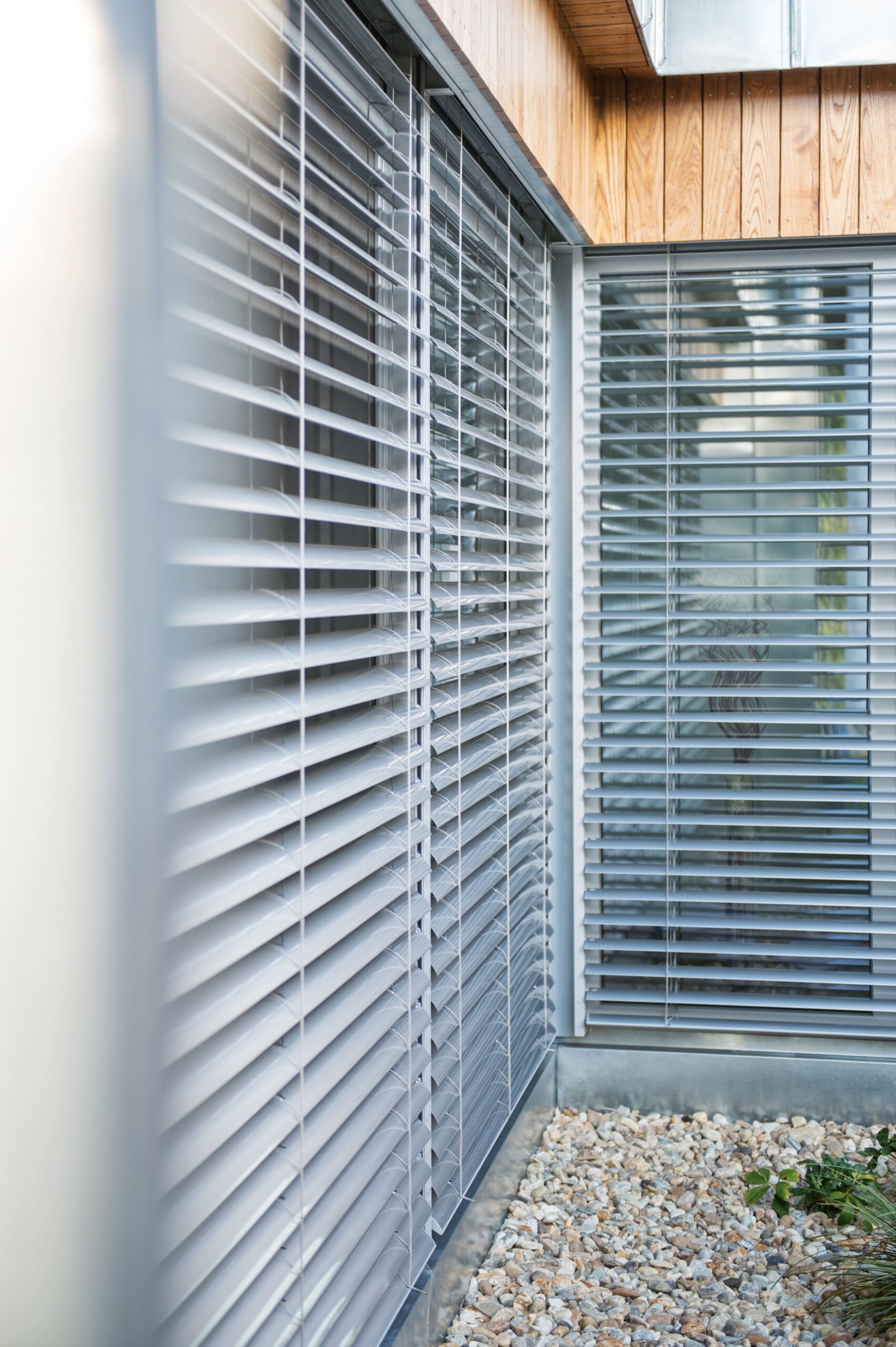 Eckfenster in grau mit heruntergelassenen Raffstore