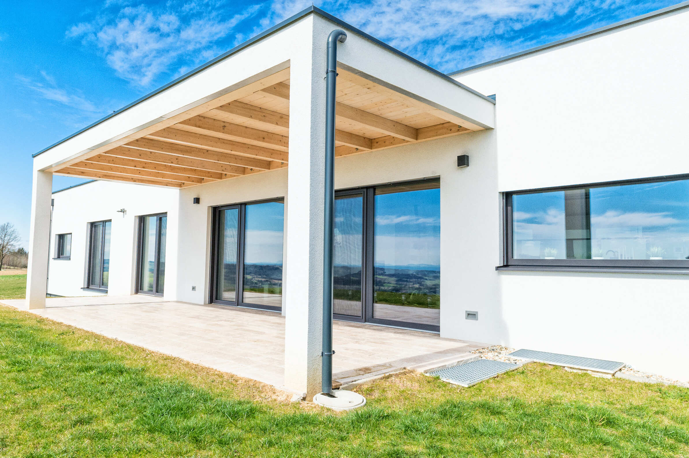 Außenansicht Haus mit Terrassenüberdachung, Fenster und Terrassentüren mit Alurahmen in anthrazit