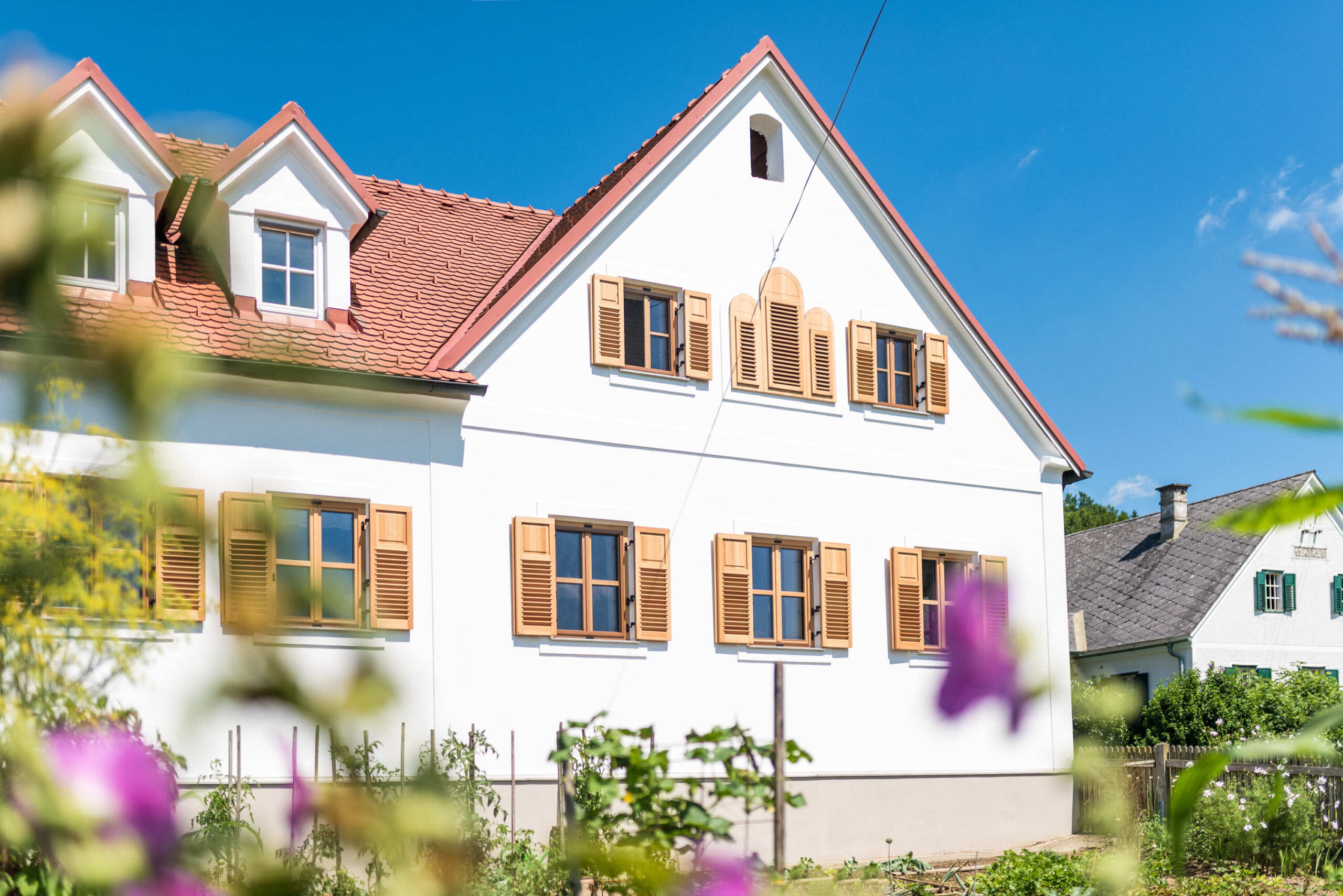 Außenansicht Haus mit Holzfenster und Fensterläden aus Holz