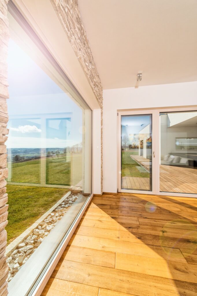 lichtdurchfluteter Raum mit großen Fensterflächen und Terrassentüren
